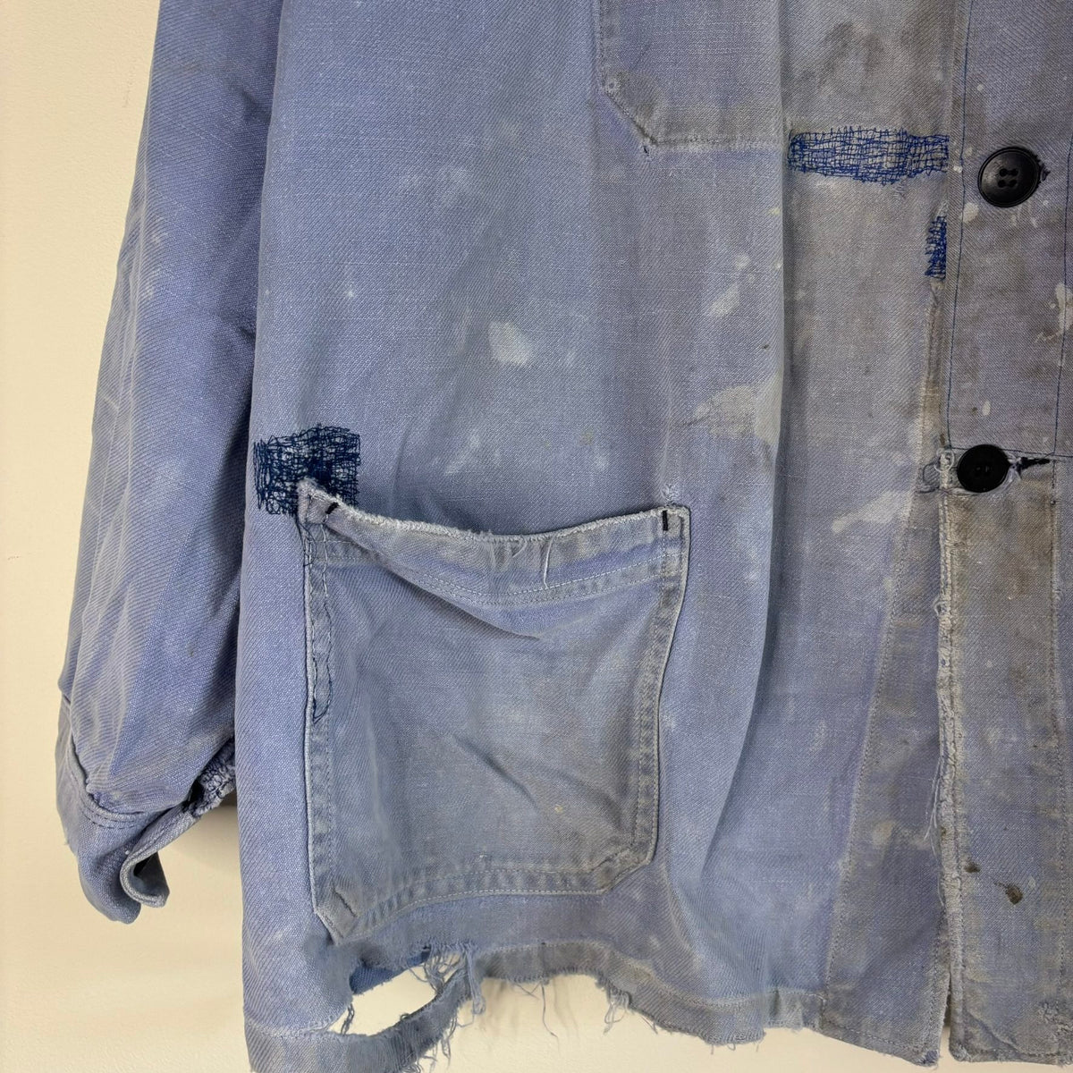 Vintage 1950s blue chore jacket with patchwork repairs and contrast panels, cotton twill.