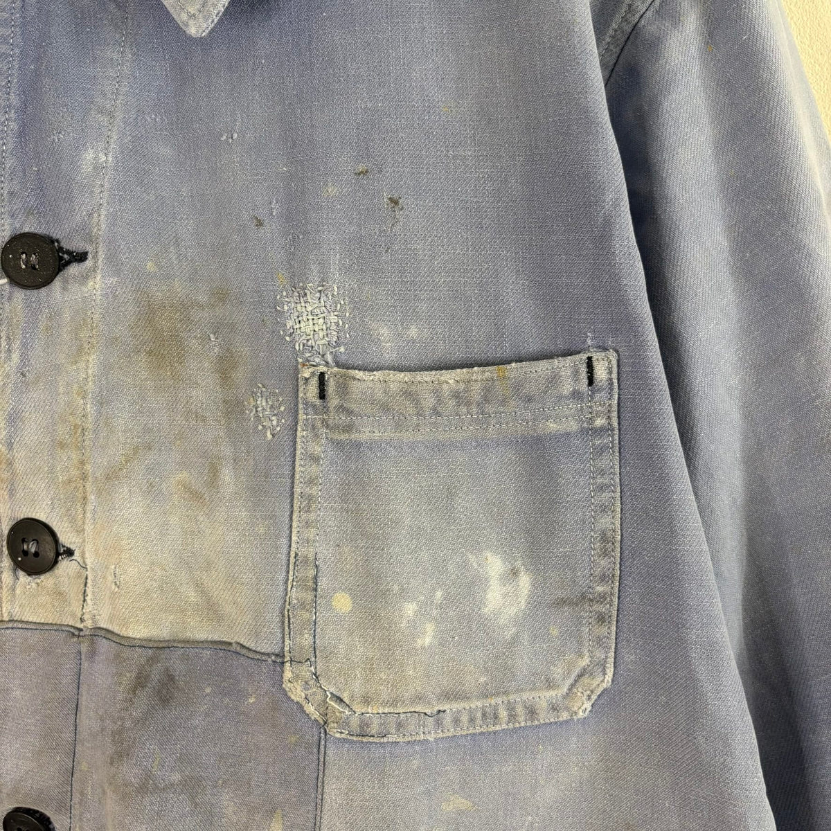 Vintage 1950s blue chore jacket with patchwork repairs and contrast panels, cotton twill.