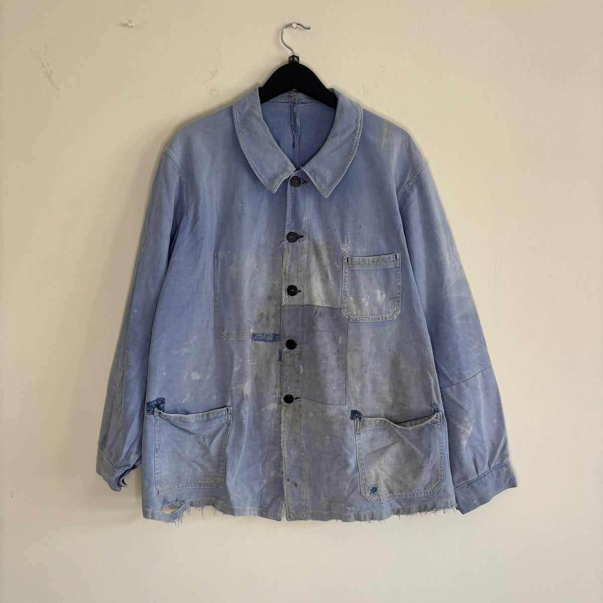 Vintage 1950s blue chore jacket with patchwork repairs and contrast panels, cotton twill.