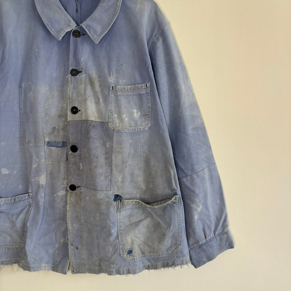 Vintage 1950s blue chore jacket with patchwork repairs and contrast panels, cotton twill.