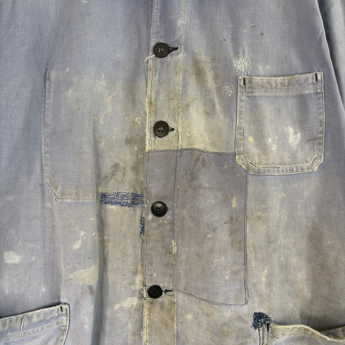 Vintage 1950s blue chore jacket with patchwork repairs and contrast panels, cotton twill.