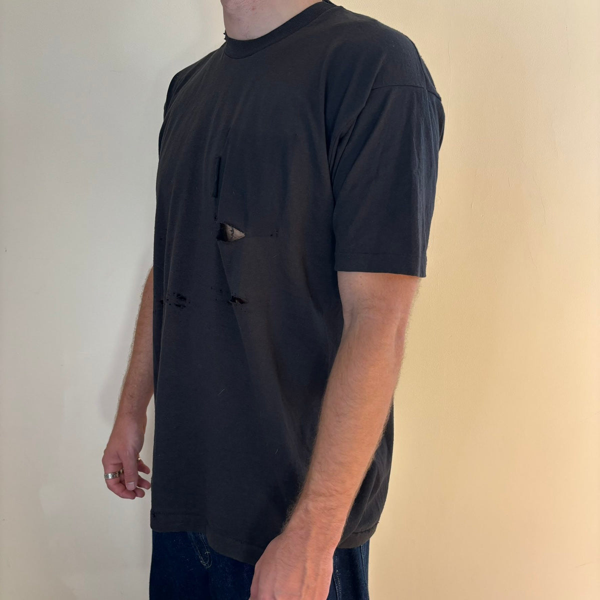 Vintage black band t-shirt single-stitch with ghost pocket detail and faded charcoal color.