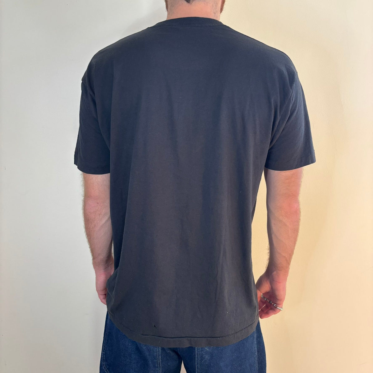 Vintage black band t-shirt single-stitch with ghost pocket detail and faded charcoal color.