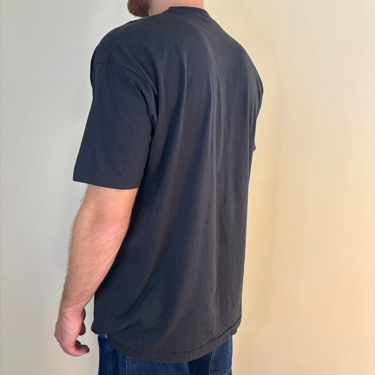Vintage black band t-shirt single-stitch with ghost pocket detail and faded charcoal color.