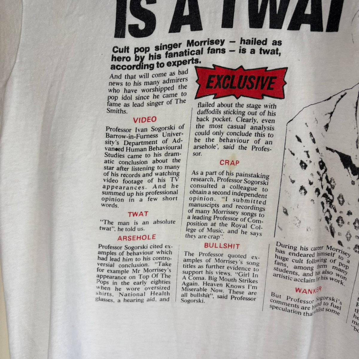 Oneita black graphic tee featuring Morrissey tabloid print and red "EXCLUSIVE" flash.
