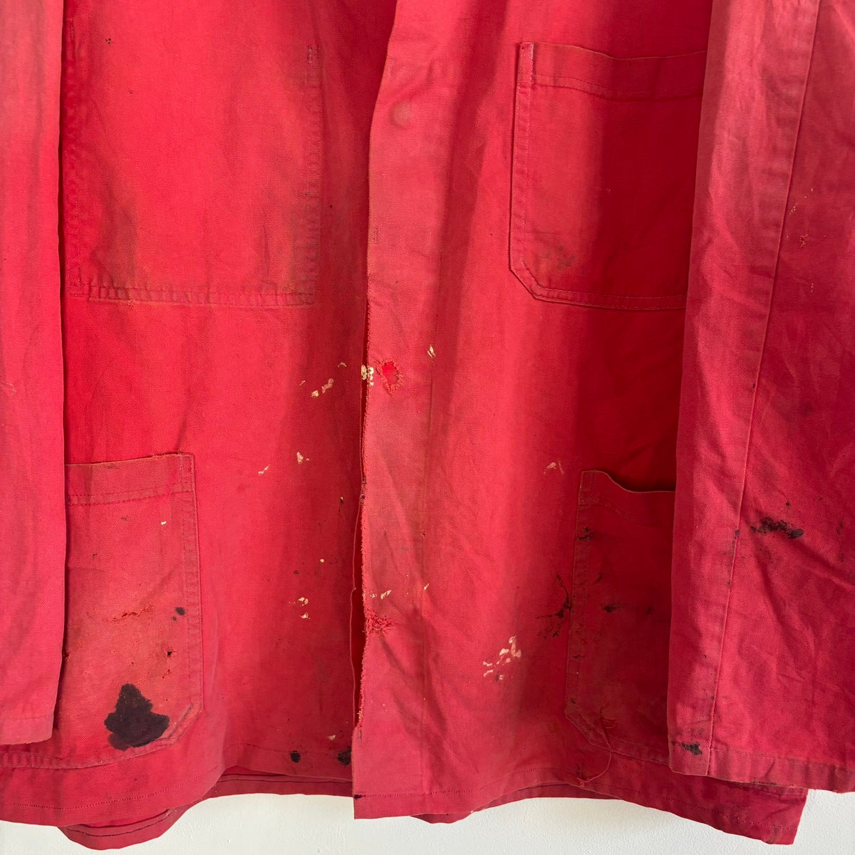 Vintage Euro workwear red chore jacket with faded paint splatters and three-pocket design.